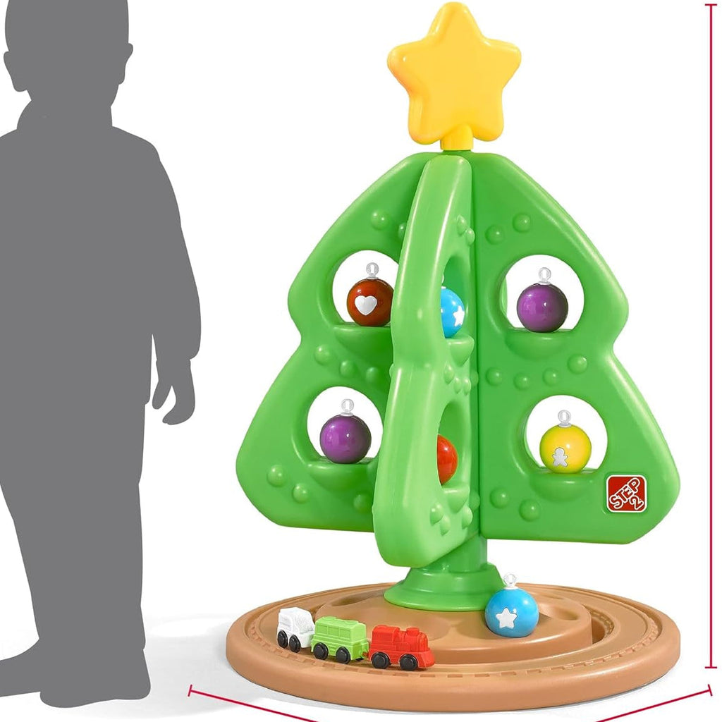 Grüner interaktiver Weihnachtsbaum mit bunten Spielelementen und kleiner Spielzeugeisenbahn