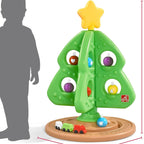 Grüner interaktiver Weihnachtsbaum mit bunten Spielelementen und kleiner Spielzeugeisenbahn