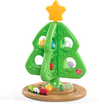 Grüner interaktiver Weihnachtsbaum mit bunten Spielelementen und kleiner Spielzeugeisenbahn