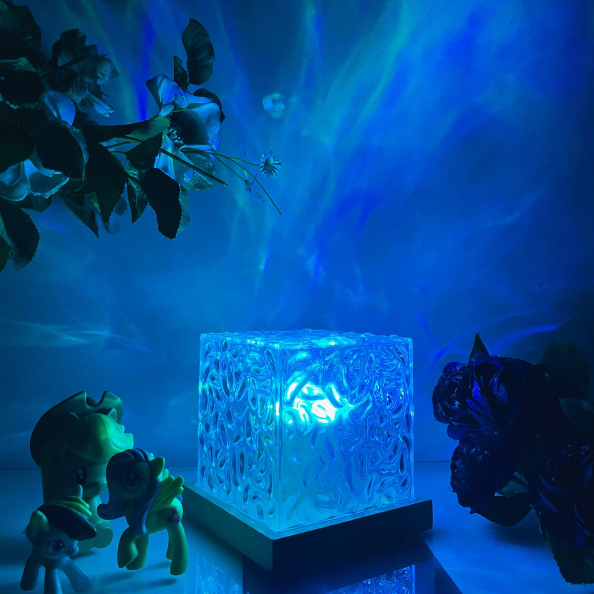 Aurora-Lampe in Würfelform mit strukturierter transparenter Lichtfläche und dunkler Basis in Holzoptik