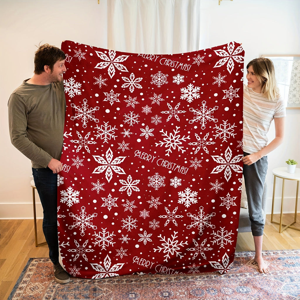 Rote Fleecedecke mit weißem Schneeflockenmotiv über einem Sessel