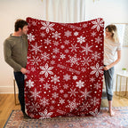 Rote Fleecedecke mit weißem Schneeflockenmotiv über einem Sessel