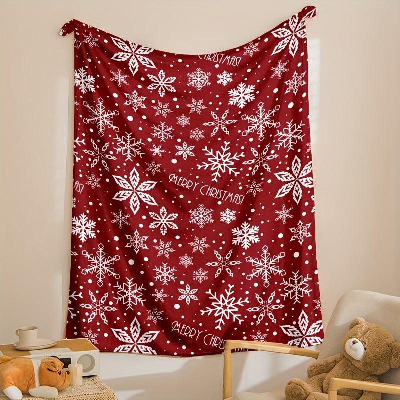 Rote Fleecedecke mit weißem Schneeflockenmotiv über einem Sessel