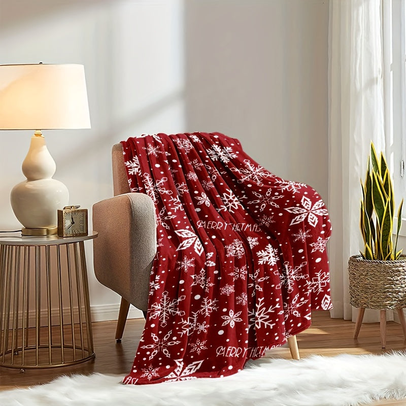 Rote Fleecedecke mit weißem Schneeflockenmotiv über einem Sessel