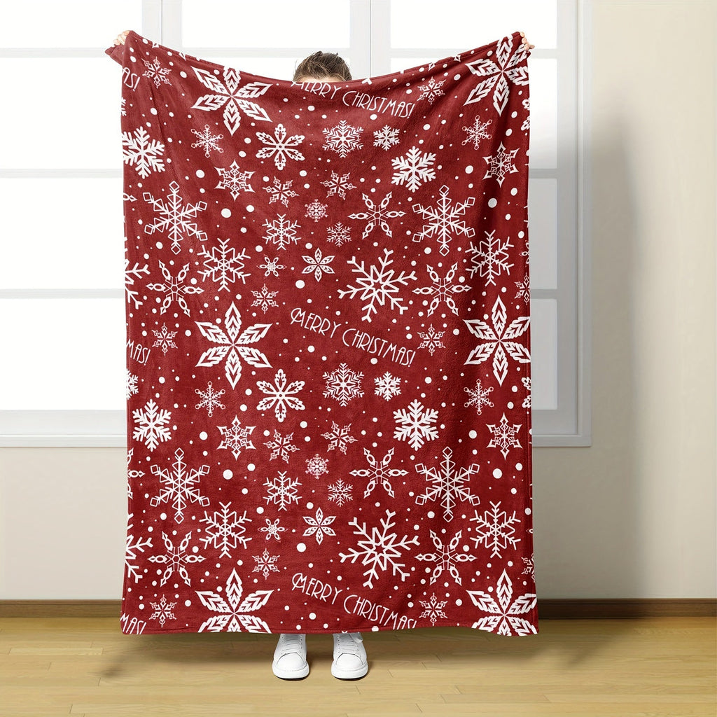 Rote Fleecedecke mit weißem Schneeflockenmotiv über einem Sessel