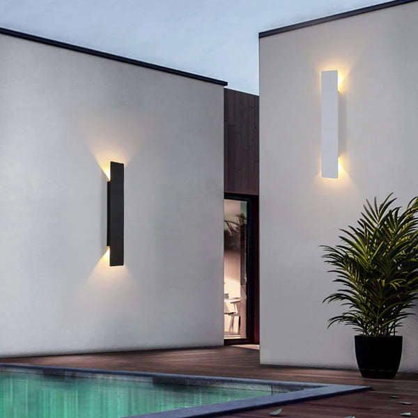 Schwarze vertikale LED-Außenwandleuchte mit warmweißem Licht an einer Fassade
