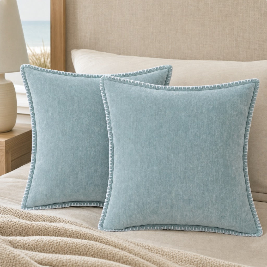Quadratisches Zierkissen mit weicher Oberfläche und dekorativer Kantenborte auf einem Sofa