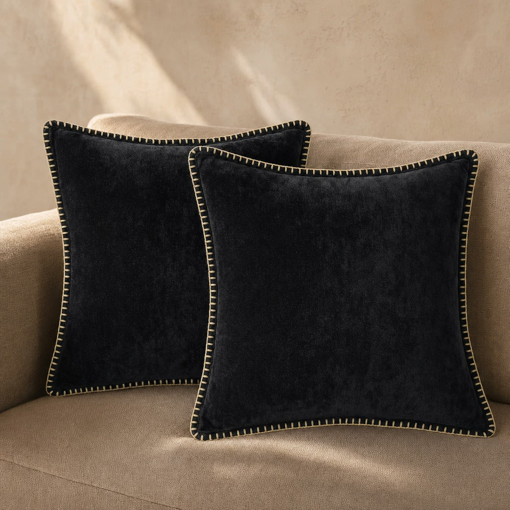 Quadratisches Zierkissen mit weicher Oberfläche und dekorativer Kantenborte auf einem Sofa