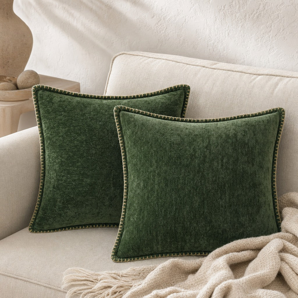Quadratisches Zierkissen mit weicher Oberfläche und dekorativer Kantenborte auf einem Sofa